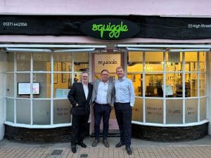Squiggle team in front of new shop signage